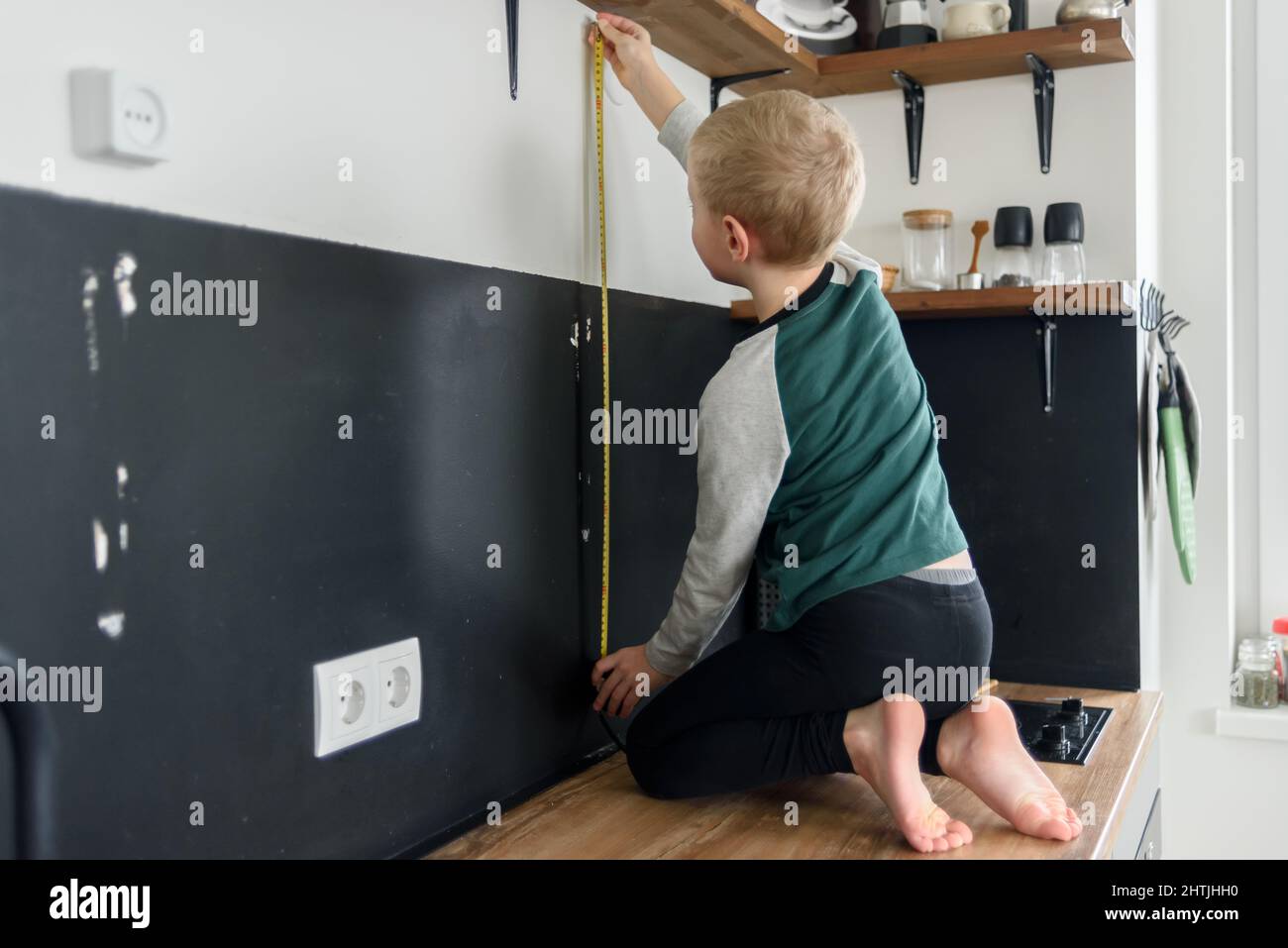https://c8.alamy.com/comp/2HTJHH0/boy-child-using-metal-tape-measure-to-renovation-works-at-home-kitchen-2HTJHH0.jpg