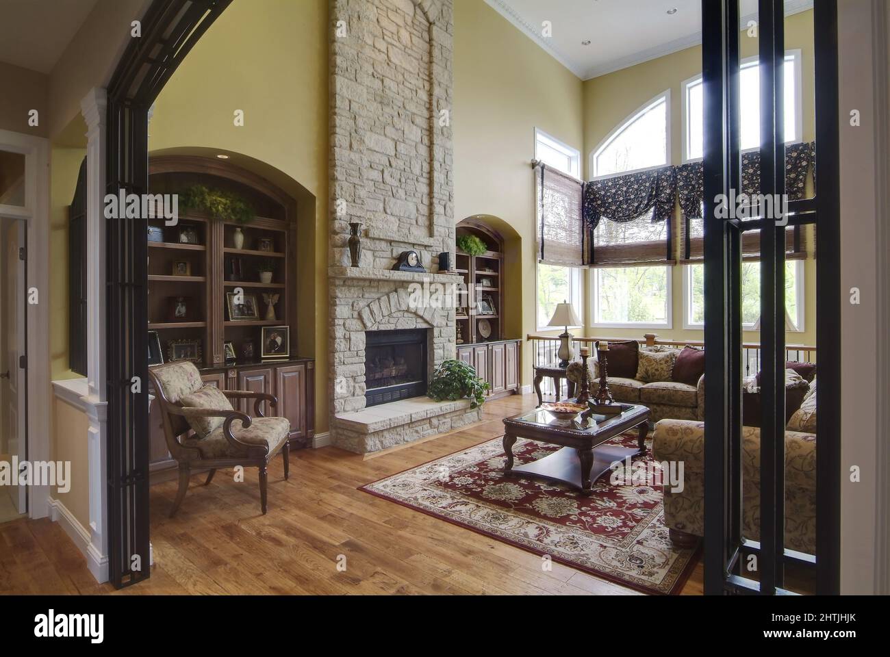 Old-fashioned living room with open wall entrance and stone fireplace Stock Photo