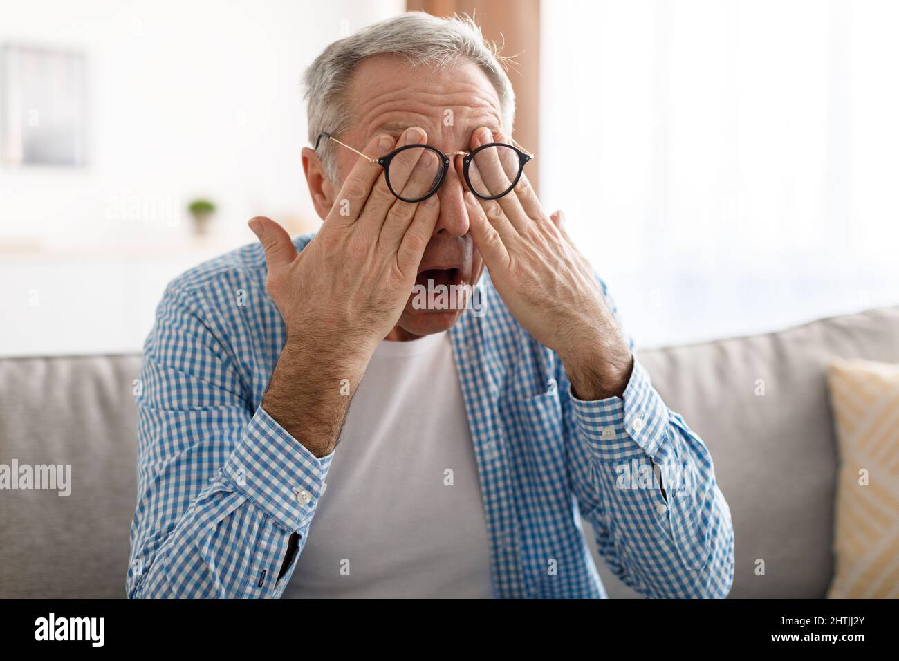 Glaucoma. Senior Man Rubbing Tired Eyes Wearing Eyeglasses Stock Photo