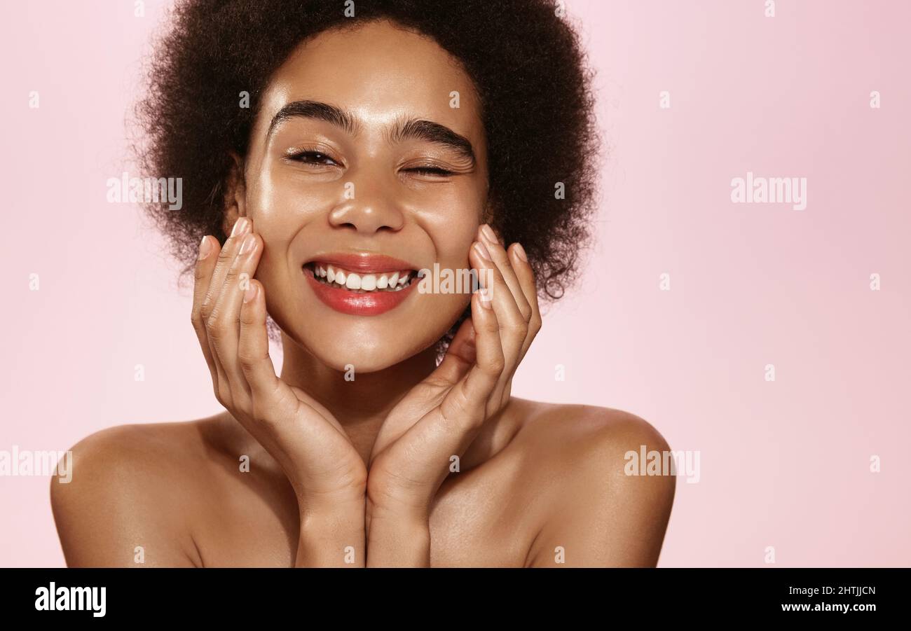 Skin care and women beauty. Smiling african woman touching her face ...