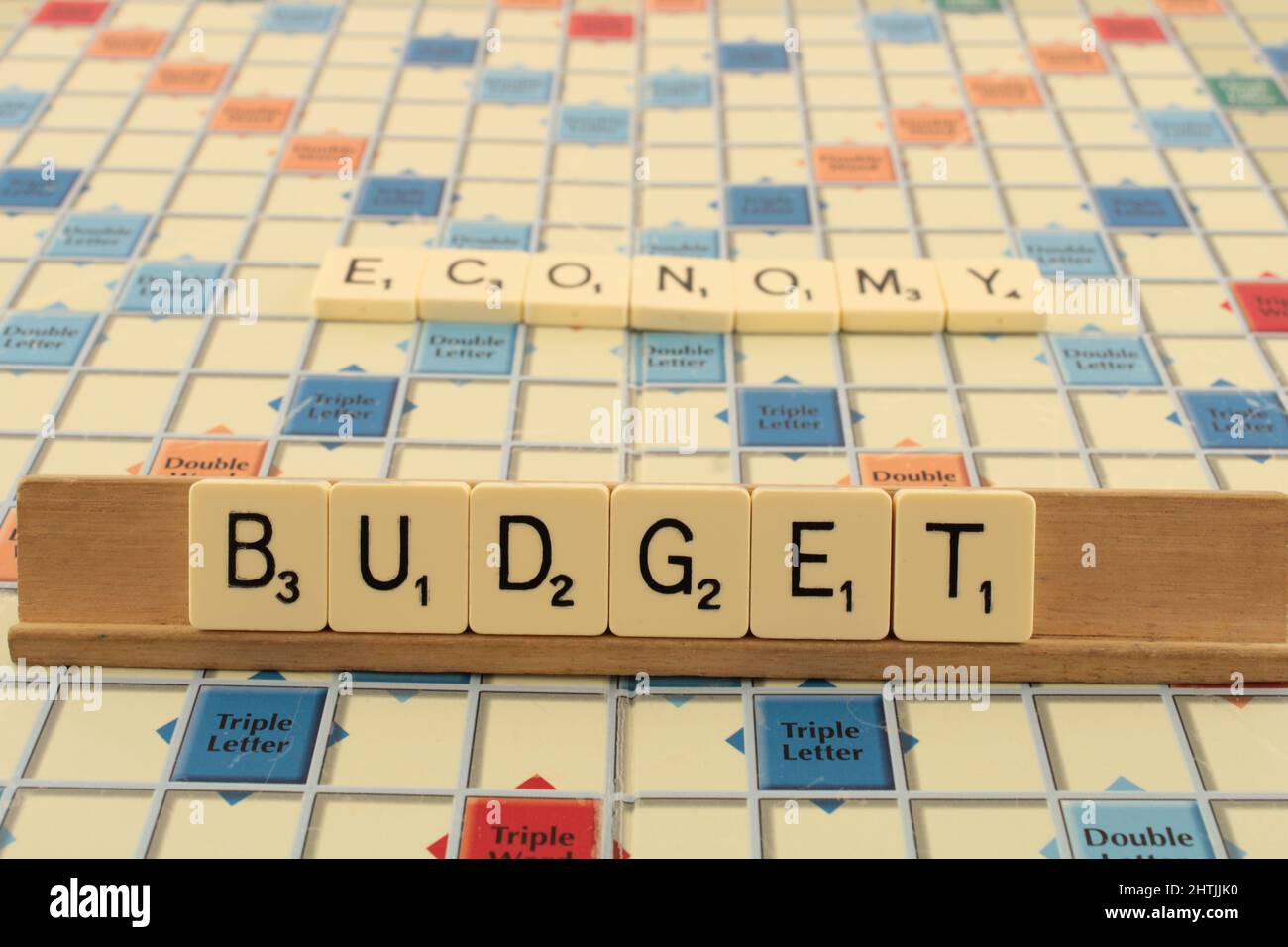 Budget on a scrabble board with the word economy in the background UK Stock Photo
