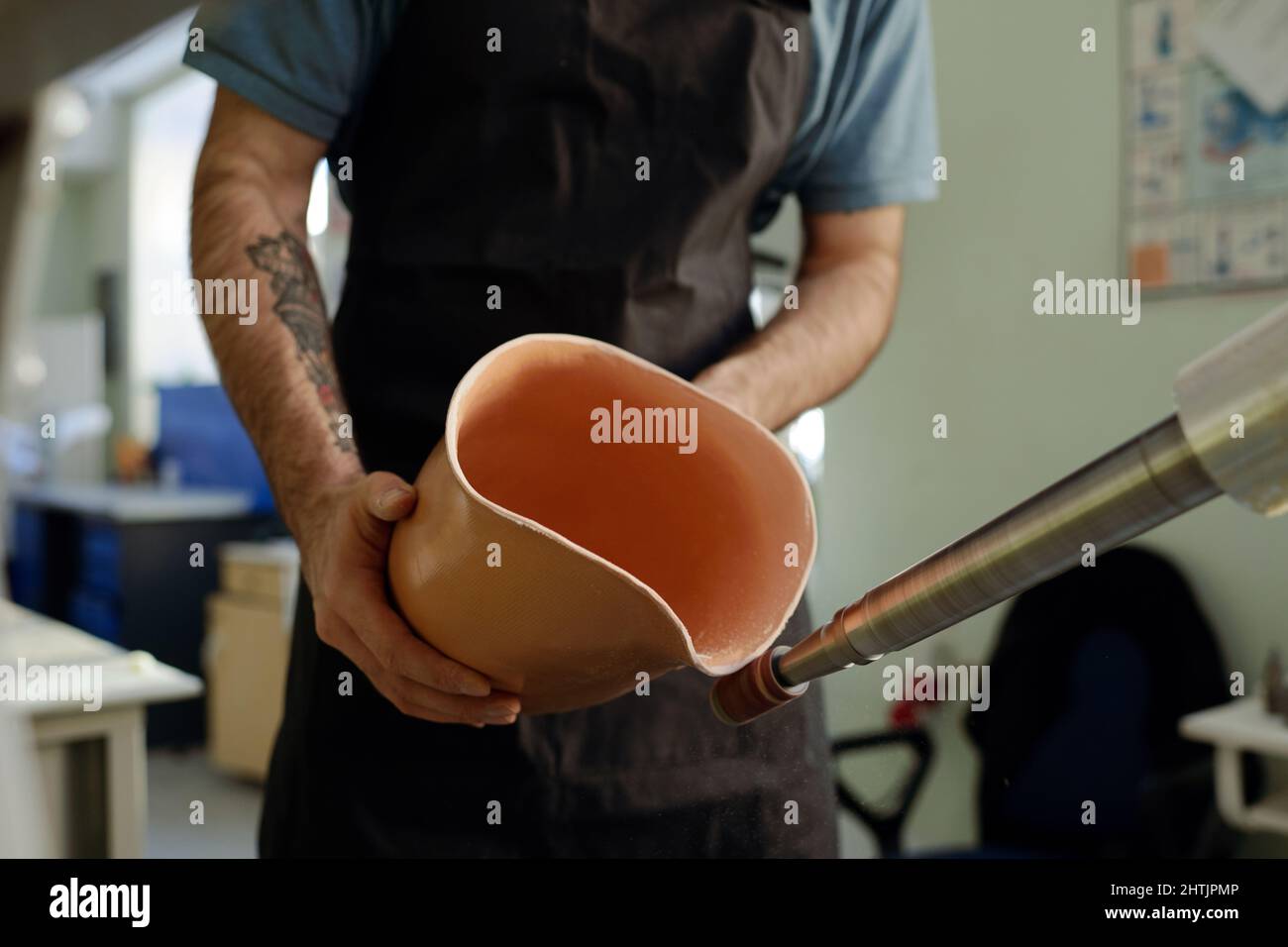 Hands of young worker holding silicone liner close to rotating ...