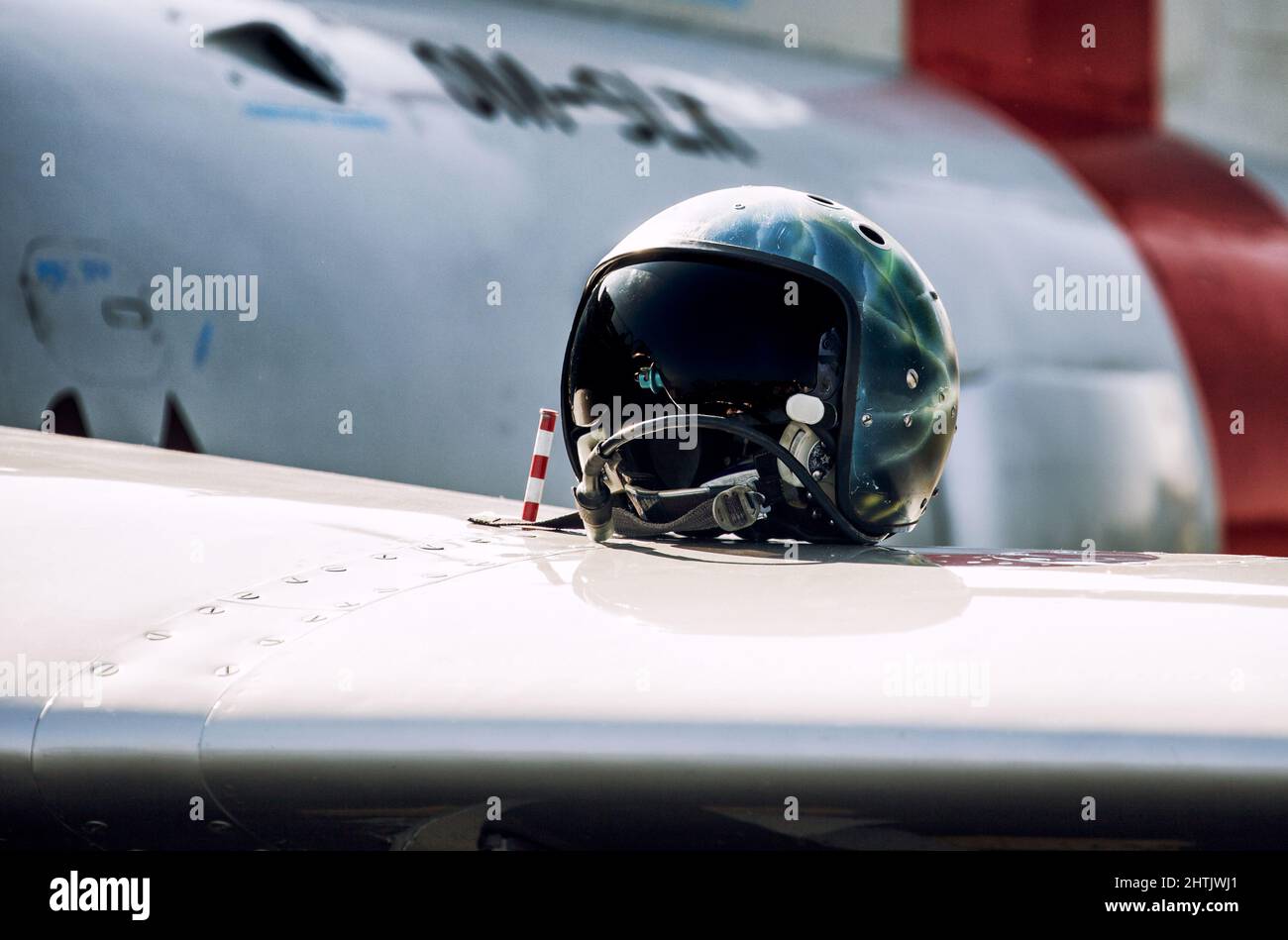 FIghter pilot helmet on wing of fighter jet. Stock Photo