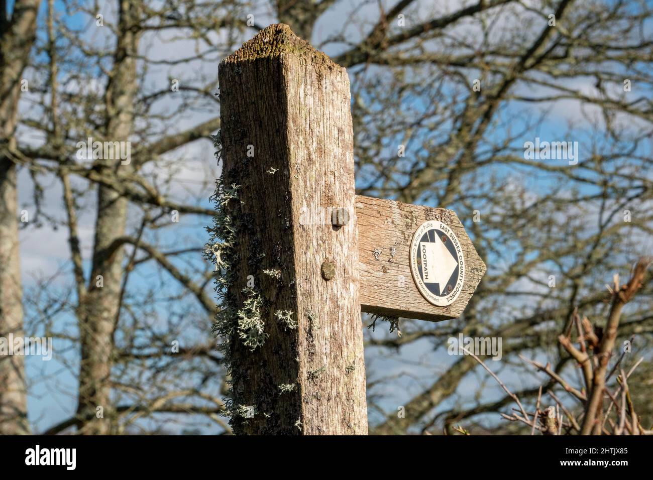 Close up top section of wooden footpath sign with added directional roundel pointing to the right Stock Photo