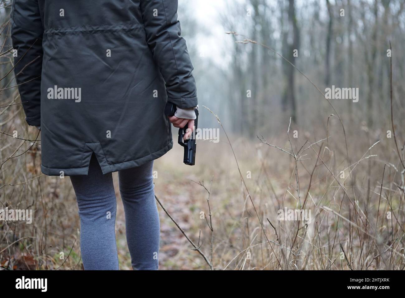 Woman with a gun in a forest Stock Photo