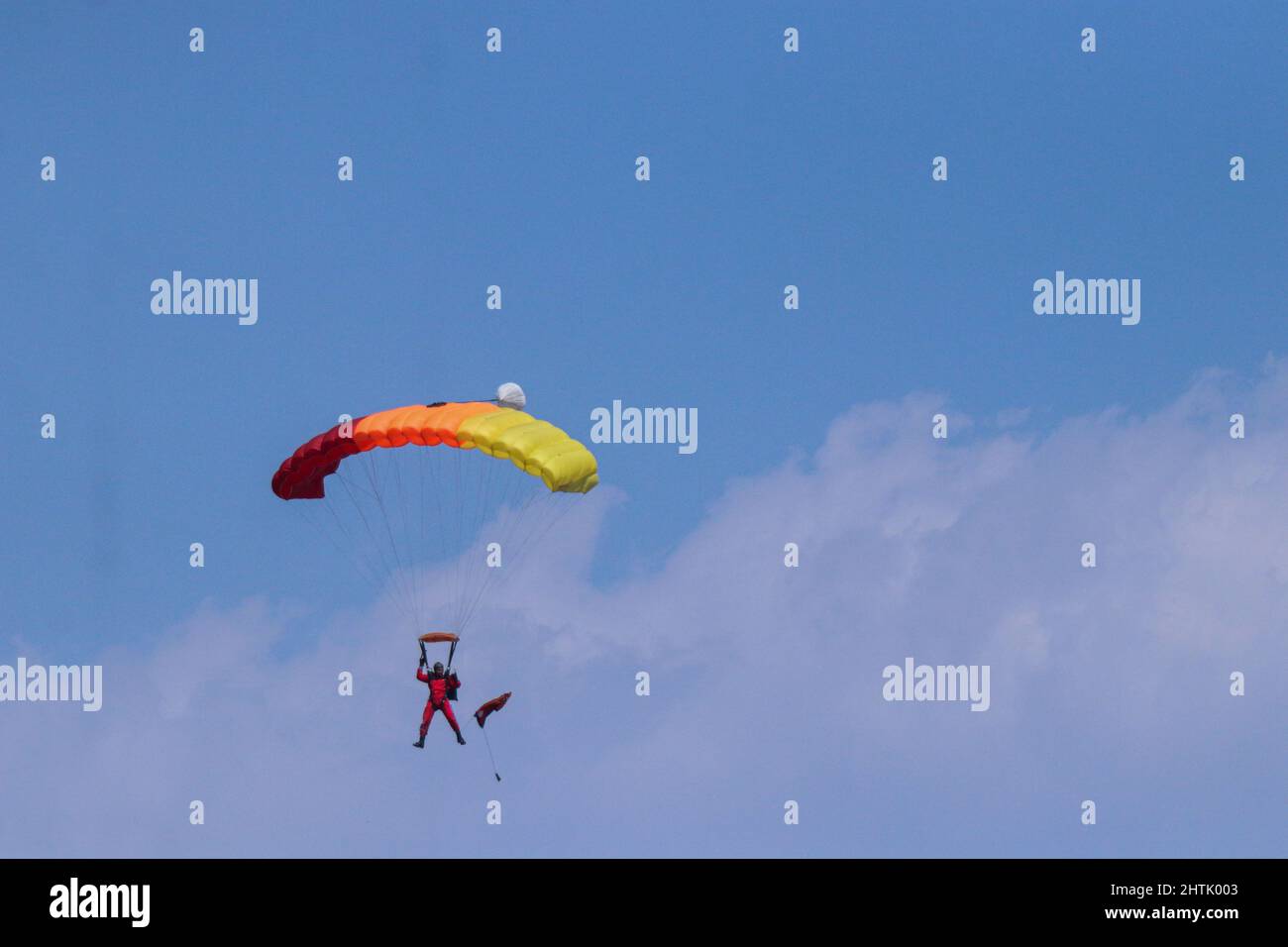 A Nepal Army paratrooper waving flag parachutes on the occasion of