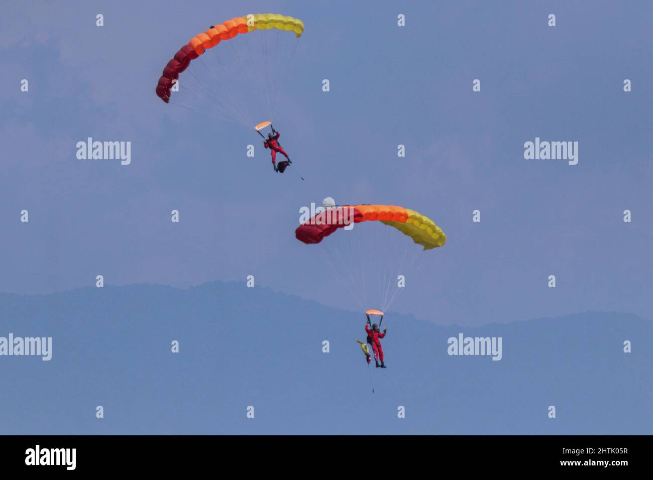 A Nepal Army paratrooper waving flag parachutes on the occasion of