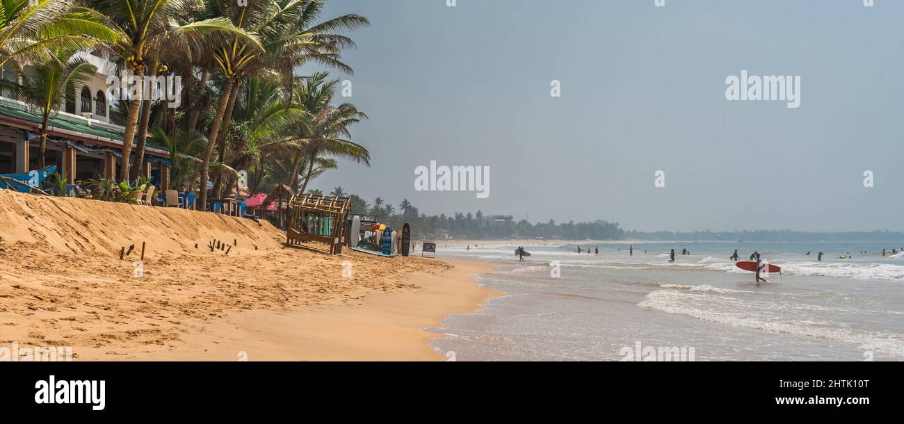 HIKKADUWA, SRI LANKA - JANUARY 22, 2022: Unidentified people on the beach at Hikkaduwa. Narigama surfer beach Stock Photo