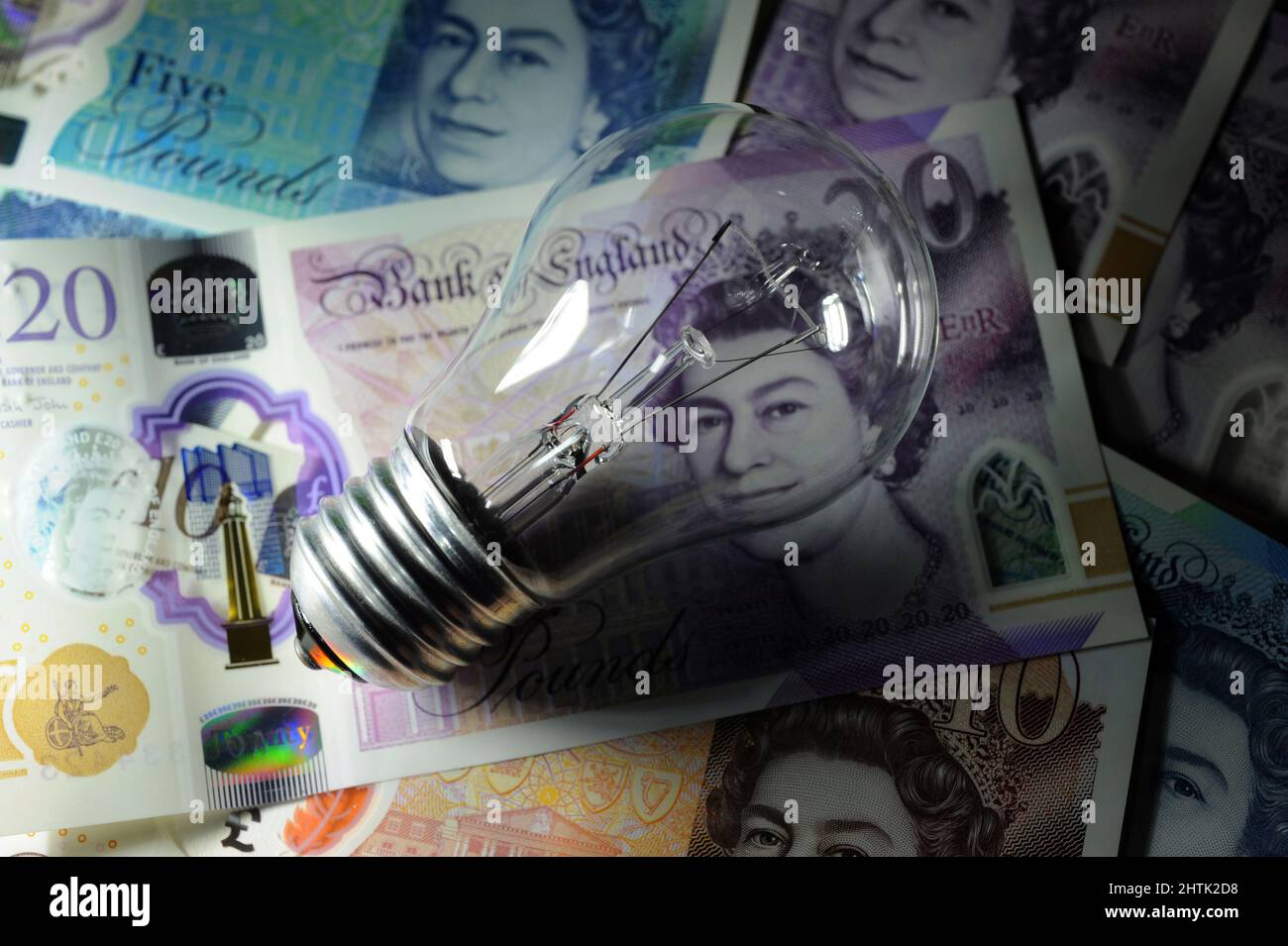 ELECTRIC LIGHT BULB WITH BRITISH CURRENCY RE ELECTRICITY BILLS COSTS PRICES ENERGY HOUSEHOLD BUDGETS ETC UK Stock Photo