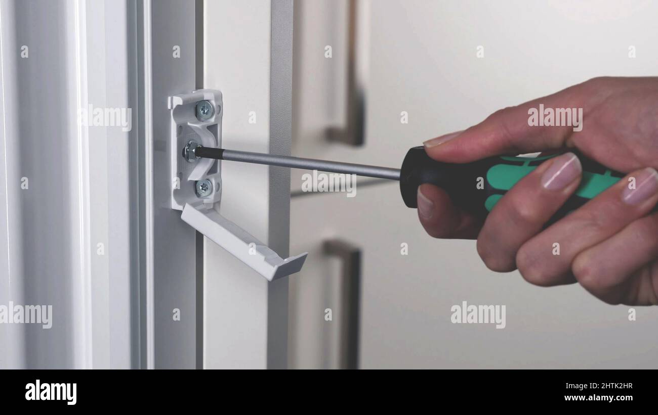 close up on hand using Screwdriver tool to driving screws background, socket screw of a aluminum window Stock Photo