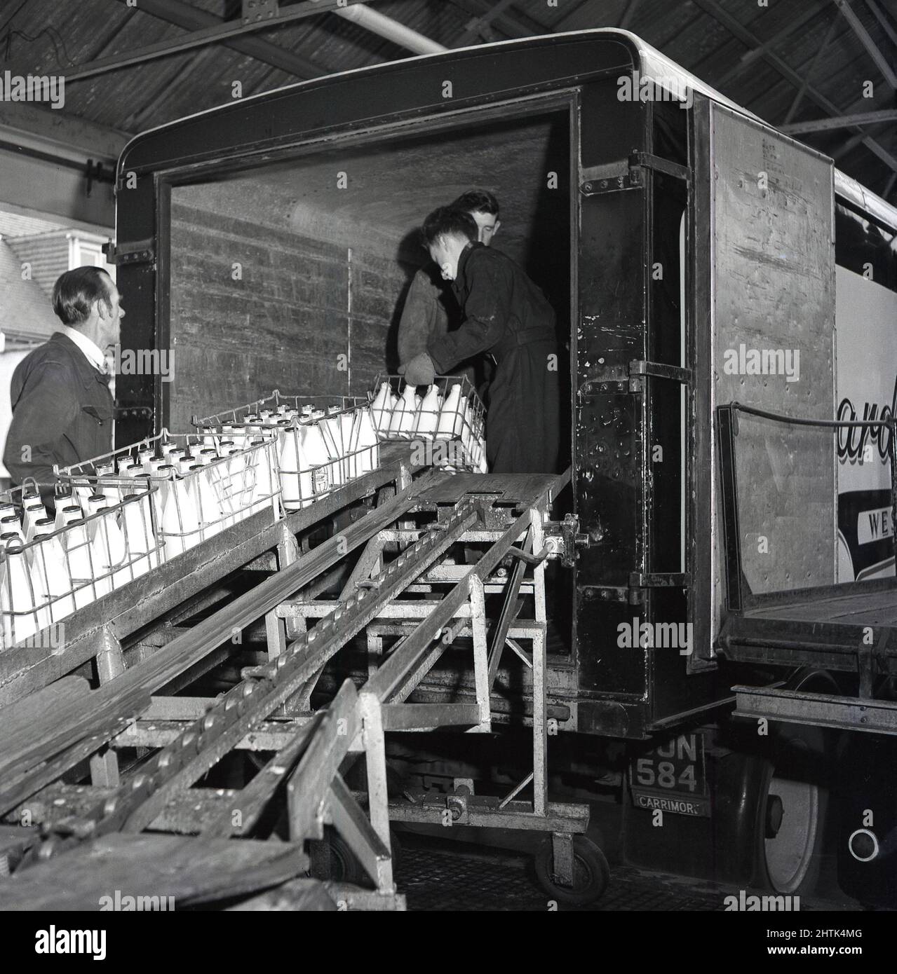 1960s, historical, inside a depot, two dairy workers standing in the