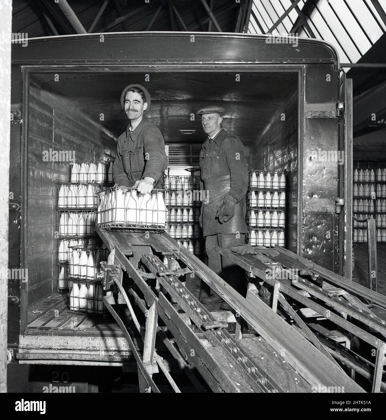1960s, historical, inside a depot, two dairy workers standing in the