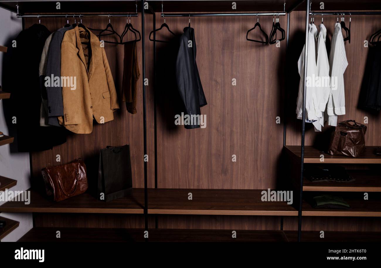 Row of men's suits and shirt hanging in a men's clothing store. dressing room in the apartment Stock Photo