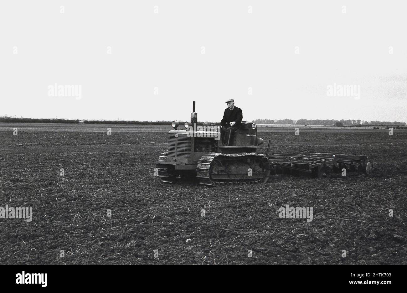 1950s, historical, a farmer on an International Harvester (BTD-6) crawler tractor with caterpillar tracks, ploughing a field, England, UK. The British built machines were designated BTD and were built in Doncaster, England. An American business, founded in 1902, International Harvester, was known as simply International or abbreviated to its intitals IH. Stock Photo