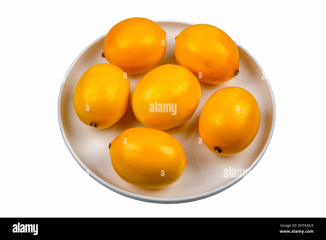 Lemons in round plate on white background Stock Photo