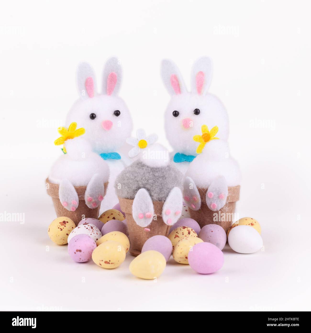 Easter bunnies with little candy chocolate easter eggs isolated on a white background Stock Photo