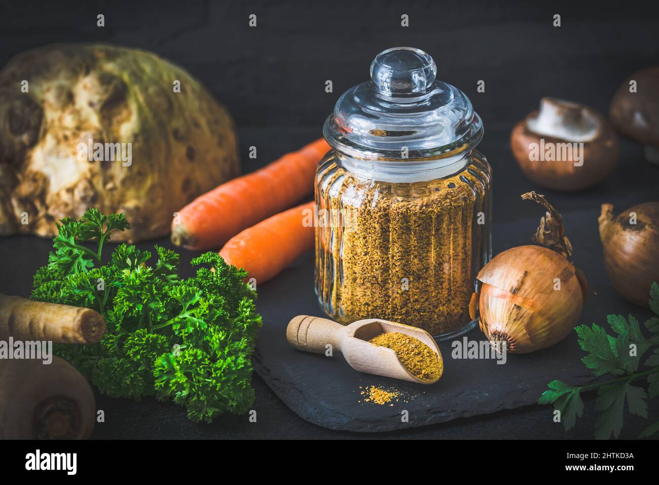 Homemade vegetable broth powder, organic vegetable stock, with raw vegetables on black