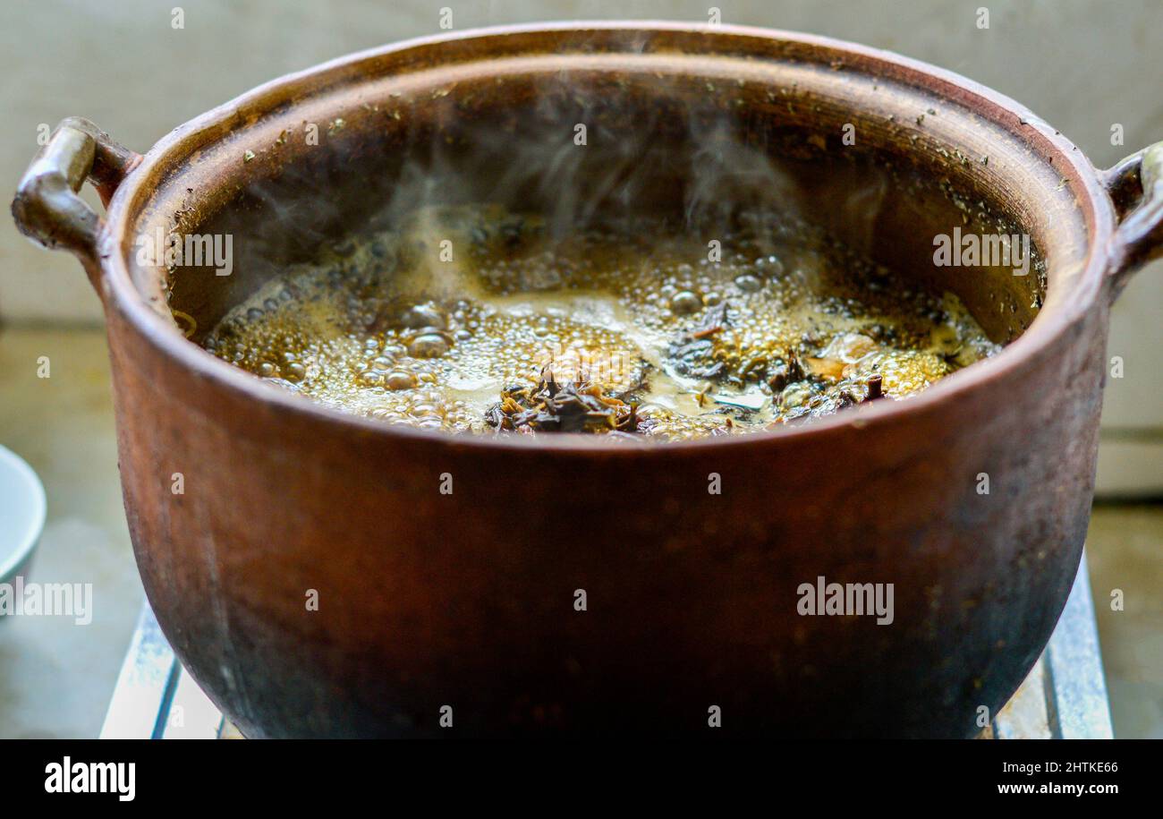 Cooking Chinese herbal soup in a clay pot. Stock Photo