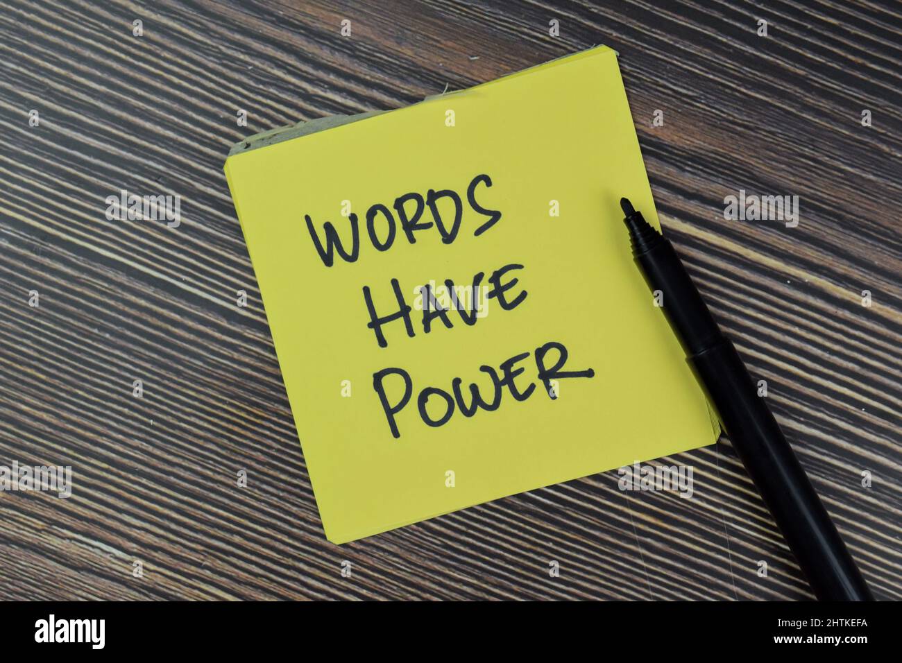 Words Have Power write on sticky notes isolated on Wooden Table. Stock Photo