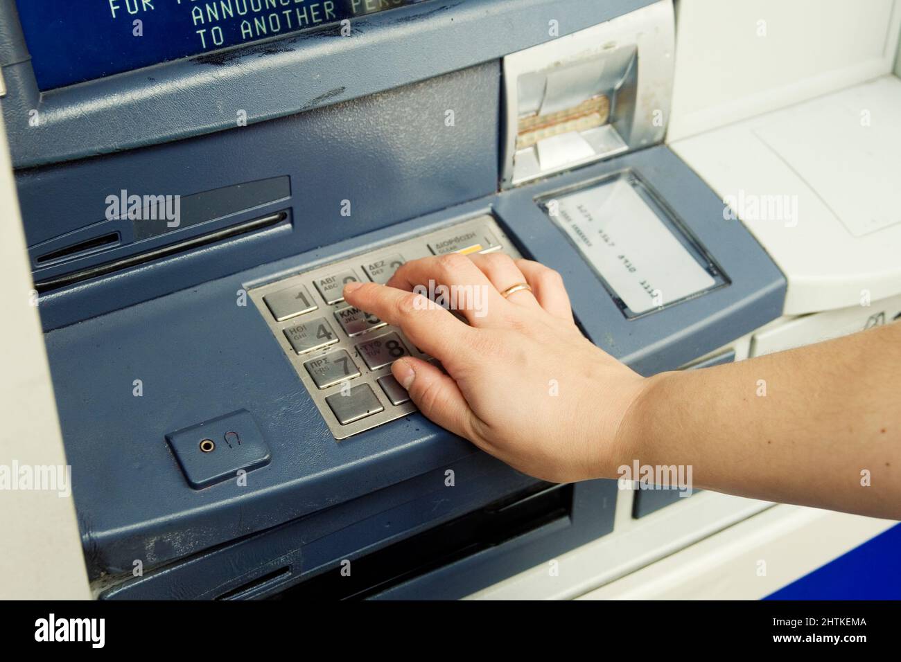Human hand entering ATM banking cash machine pin code Stock Photo
