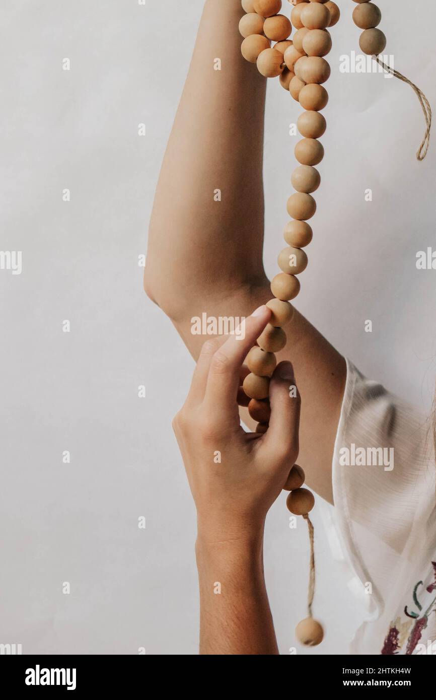 View of a female holding a rosary on a white background Stock Photo - Alamy