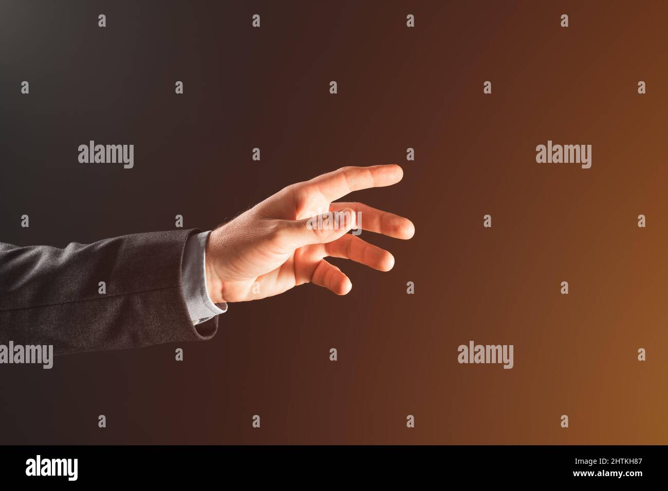 Hand of a businessman reaching for the light of hope, selective focus Stock Photo