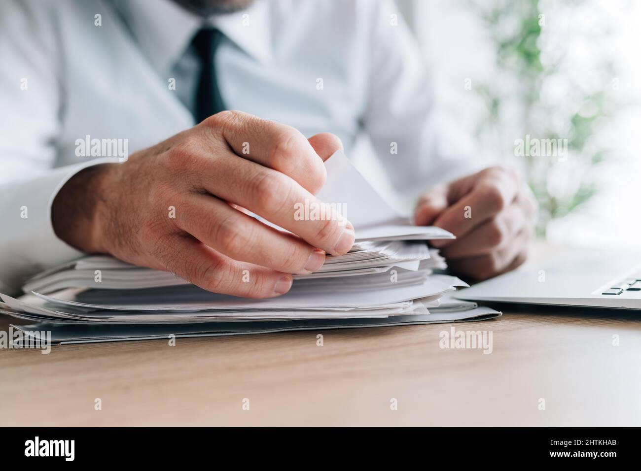HR manager reading employee candidates resumes piled on office desk, selective focus Stock Photo