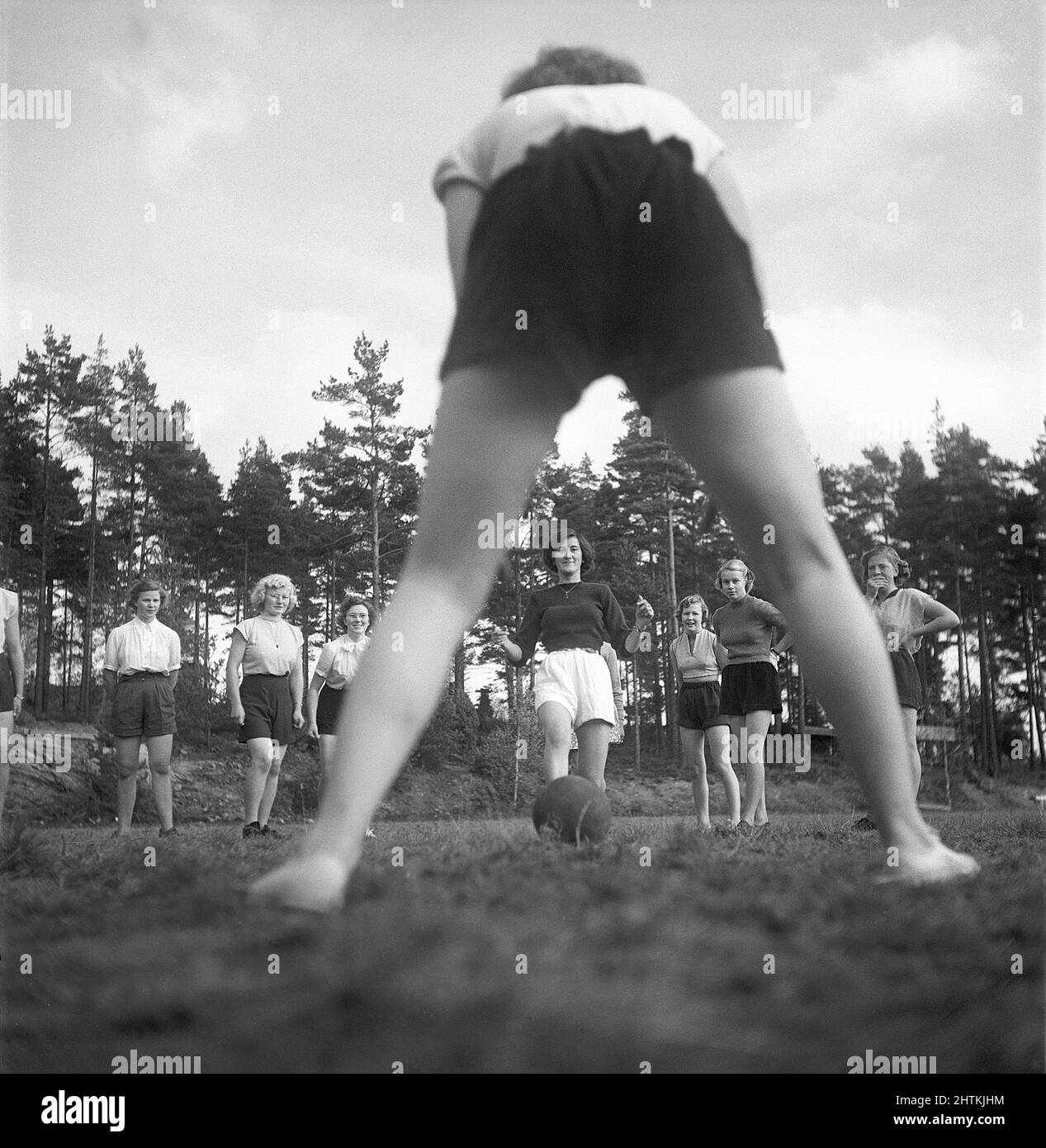 In the 1950s. A women's soccer team during practise. One by one they shoot the ball at the goalkeeper who is pictured from behind. Sweden 1951 Kristoffersson BE37-12 Stock Photo