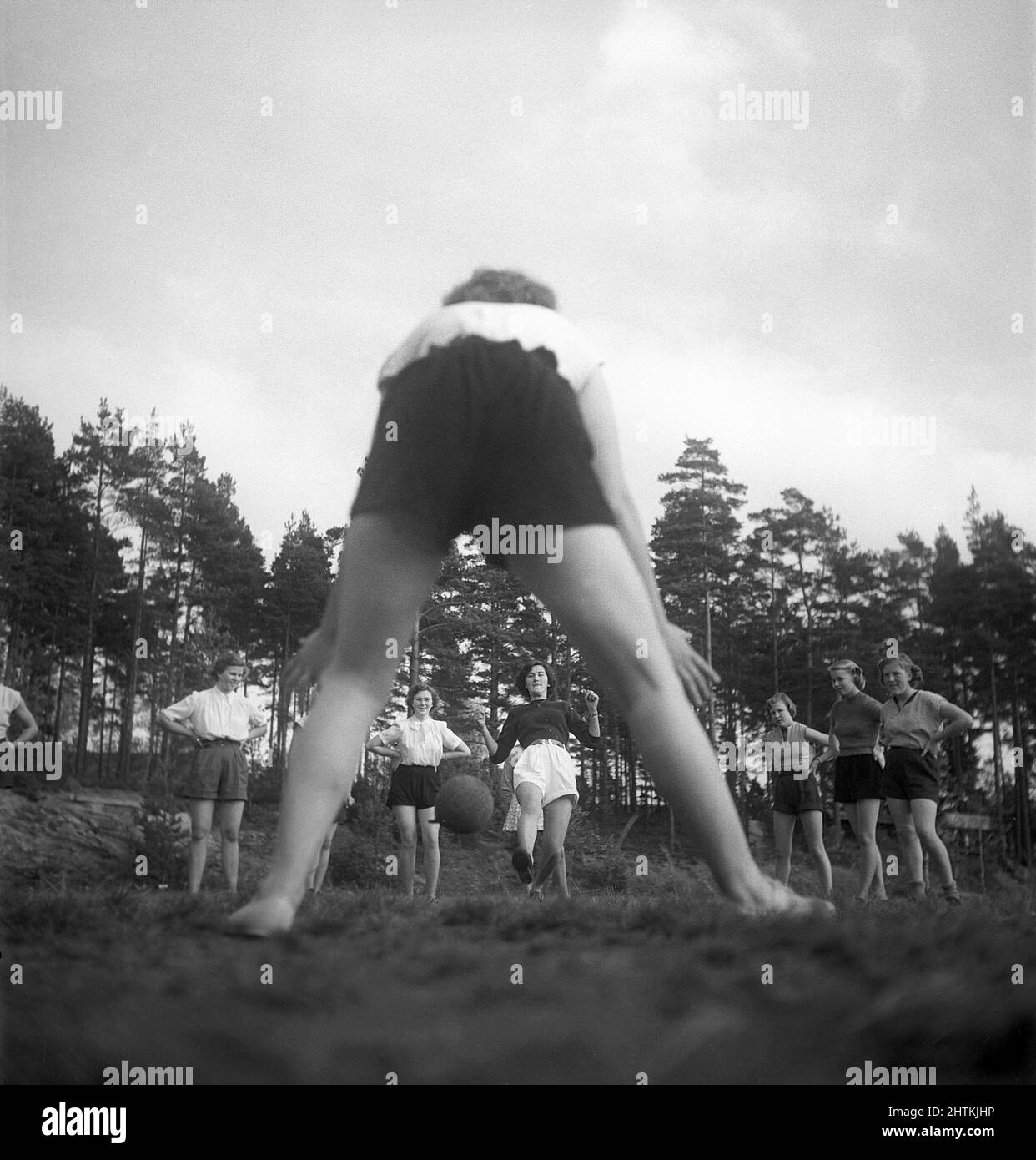 In the 1950s. A women's soccer team during practise. One by one they shoot the ball at the goalkeeper who is pictured from behind. Sweden 1951 Kristoffersson BE37-10 Stock Photo