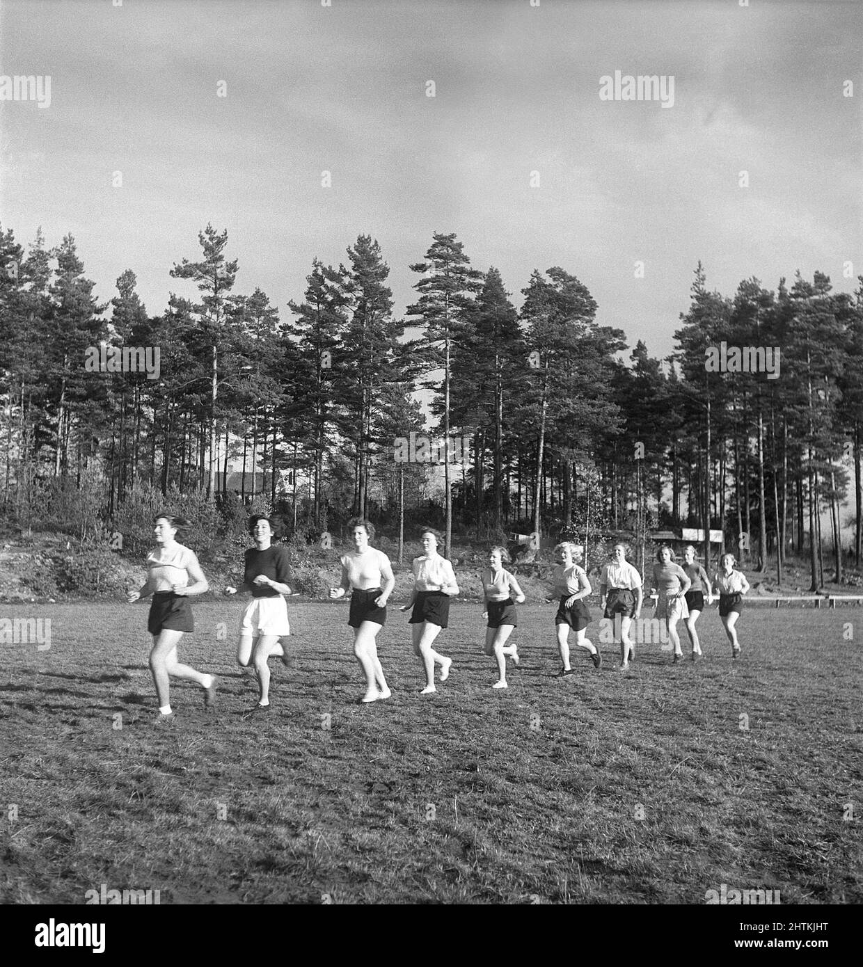In the 1950s. A women's soccer team during practise are running on the soccer field.  Sweden 1951 Kristoffersson BE37-6 Stock Photo