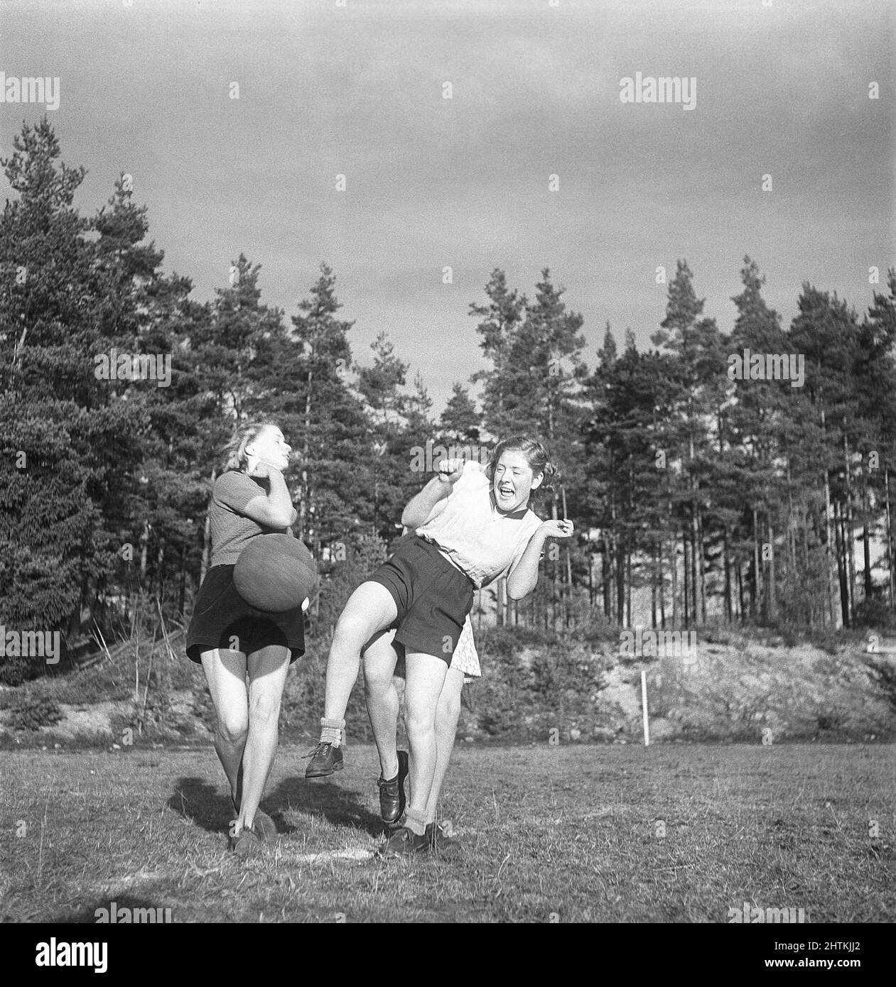 In the 1950s. A women's soccer team during practise. Three players are are fighting for the ball. Sweden 1951 Kristoffersson BE37-1 Stock Photo