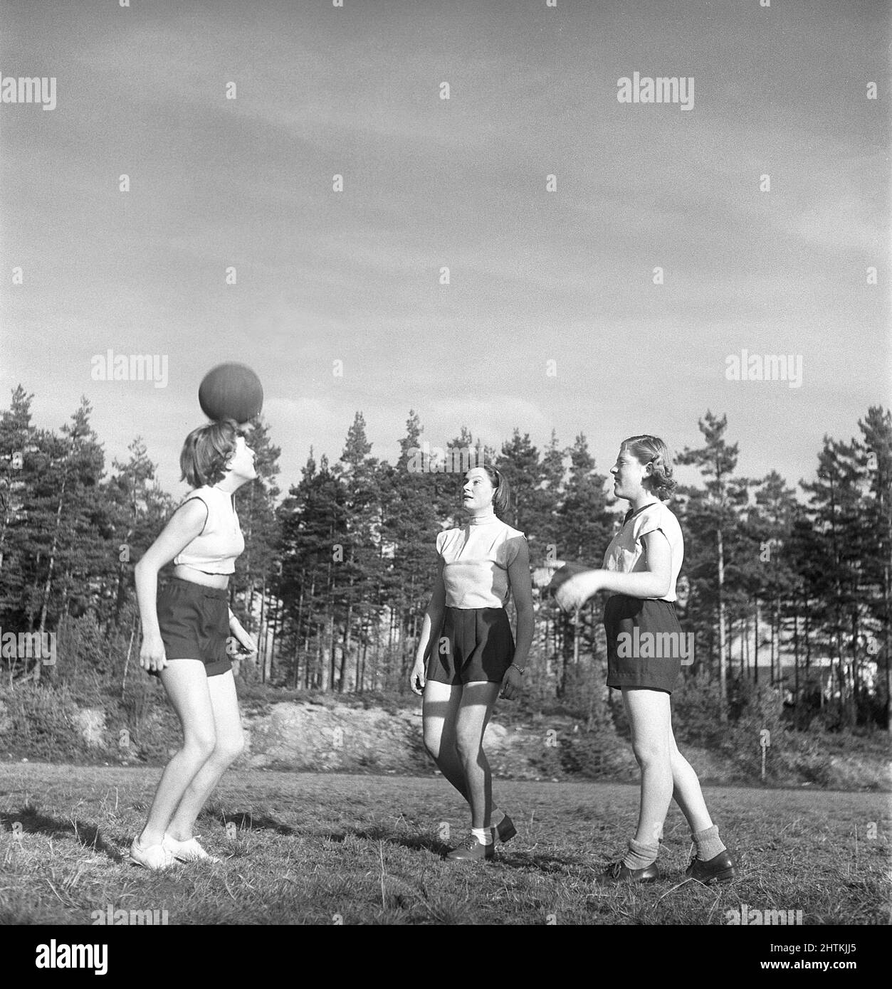 In the 1950s. A women's soccer team during practise. Three players are heading the ball between them.  Sweden 1951 Kristoffersson BE37-11 Stock Photo