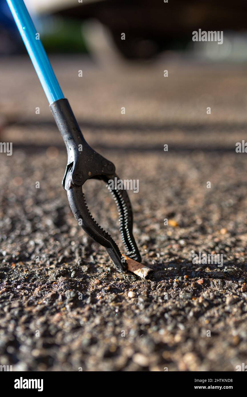 A close up of a cigarette butt that has been picked up by a litter picker.  Litter pick, rubbish, environmental concept Stock Photo