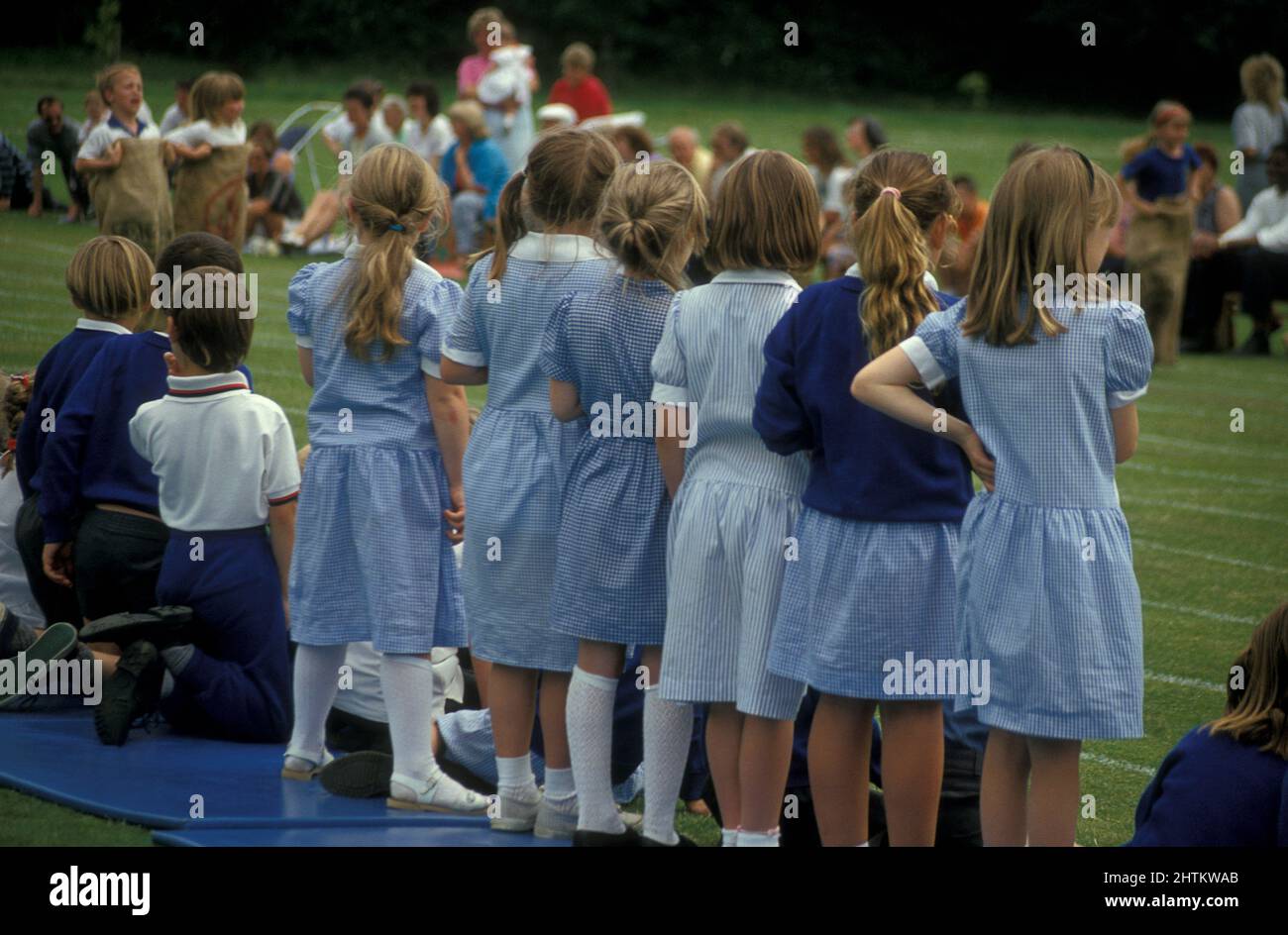row of uniformed primary school girls watching sports day event Stock Photo