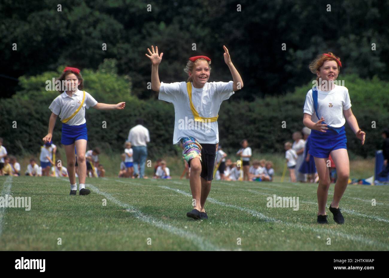 primary school sports day, girls in running race with bean bags on