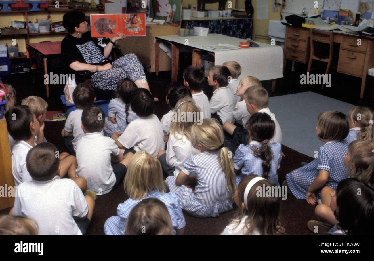 primary school children having storytime with teacher Stock Photo