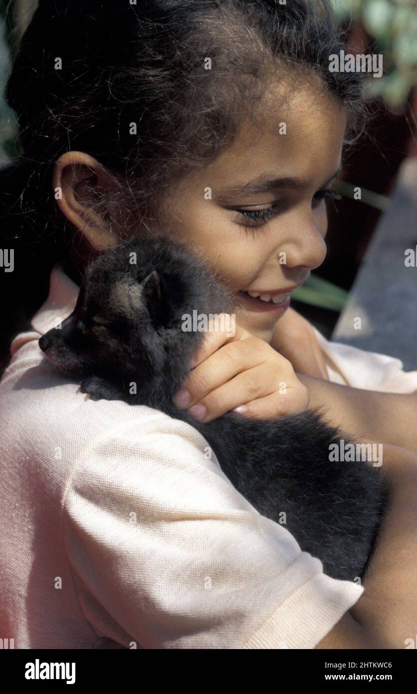 little girl cudding baby fox cub at rescue centre, UK Stock Photo