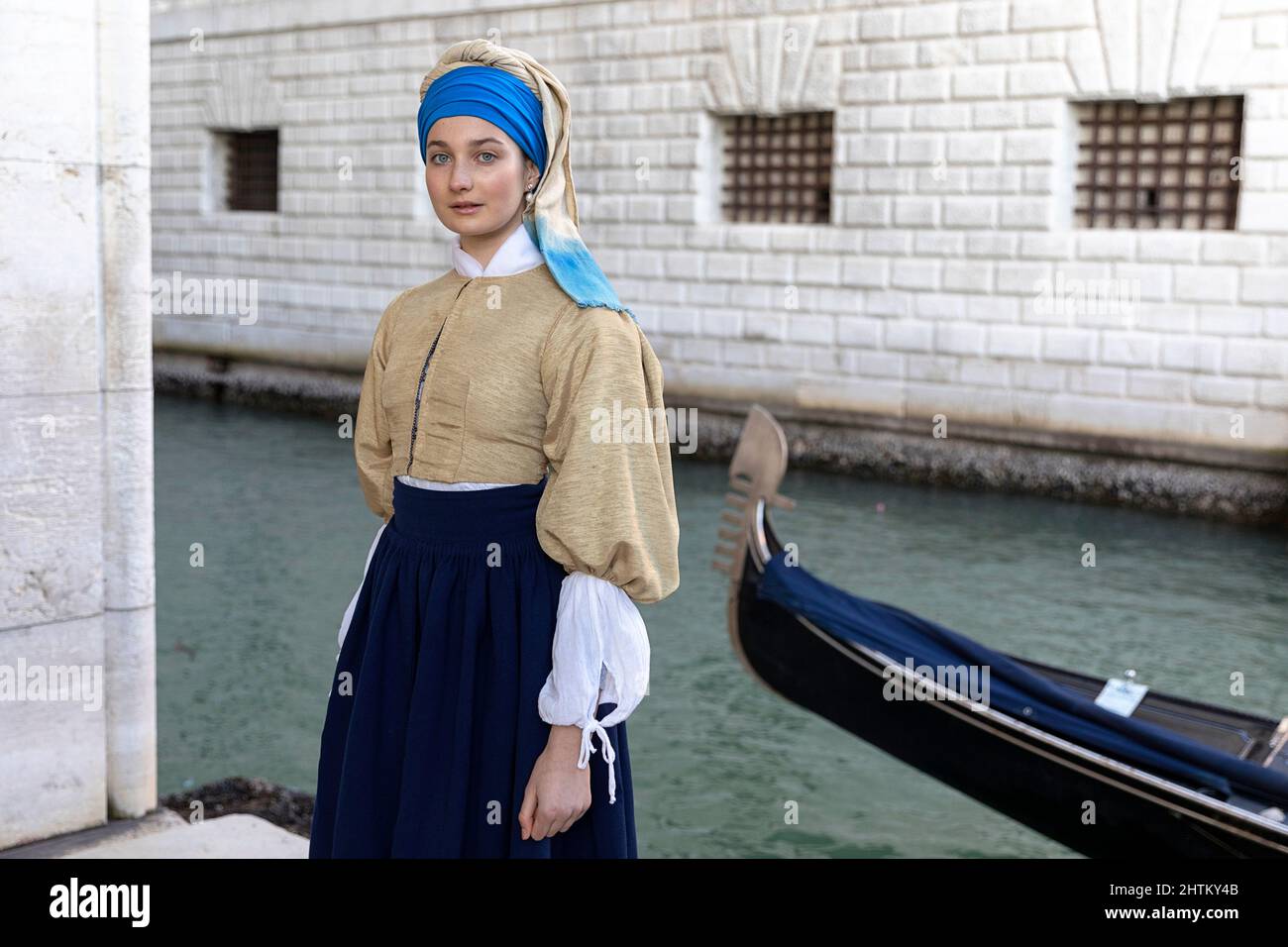 Woman in a beautiful traditional venetian costume and mask posing like Vermeer’s Girl With a Pearl Earring at the Venice carneval, venice, Italy Stock Photo