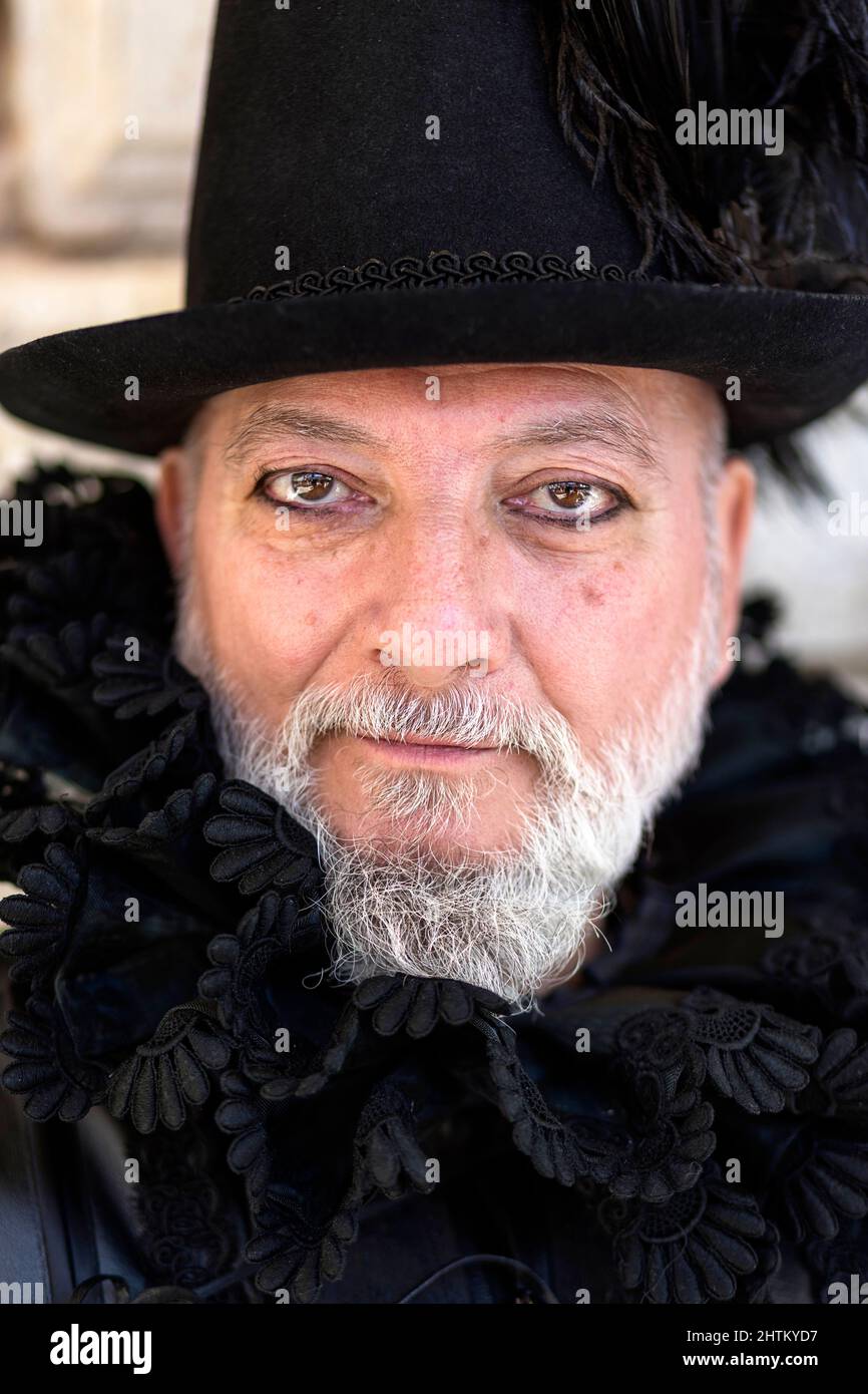 Man in a beautiful traditional venetian handmade costume and mask posing at the Venice carneval. St. Mark's Square, Venice Stock Photo