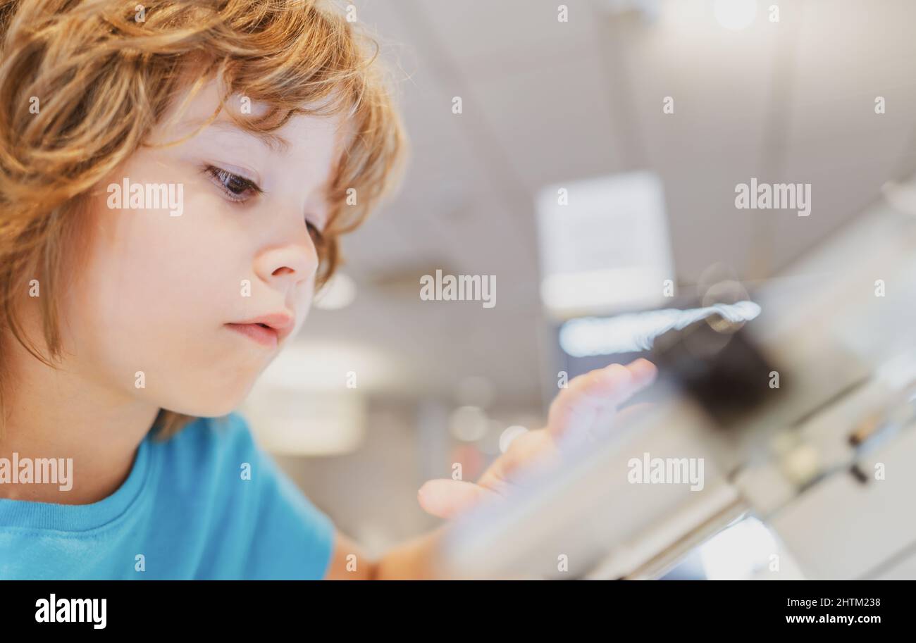 Child chooses in gadget store. Smart digital technics. Kid in computer ...