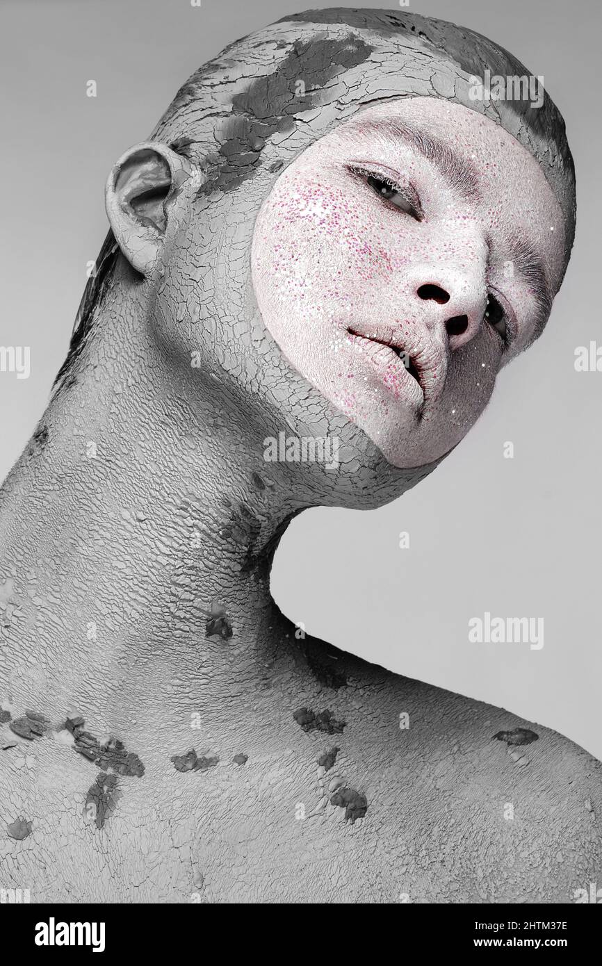 Young man with art creative make-up with mud on his face. Cosmetic mask. Stock Photo