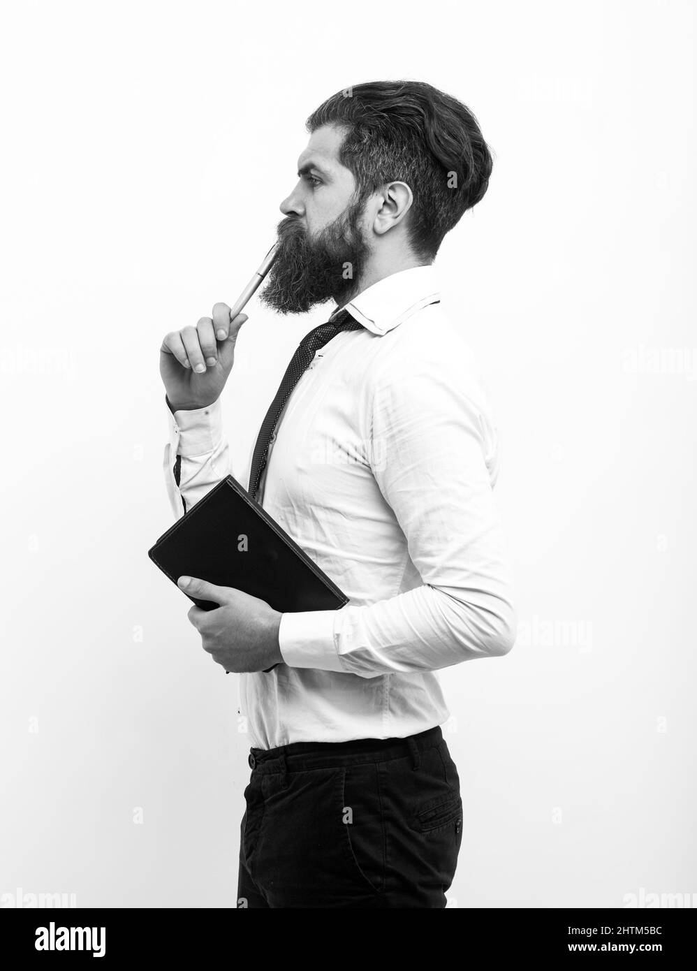 Concentrated man with pen in his mouth. Male with notepad for writing ...