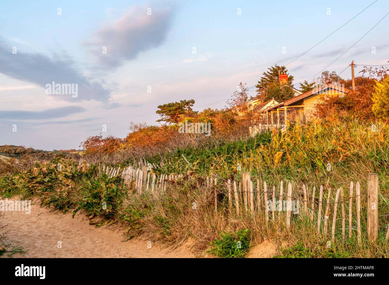 Evening light on holiday cabins in sand dunes at Old Hunstanton on the North Norfolk coast. Stock Photo