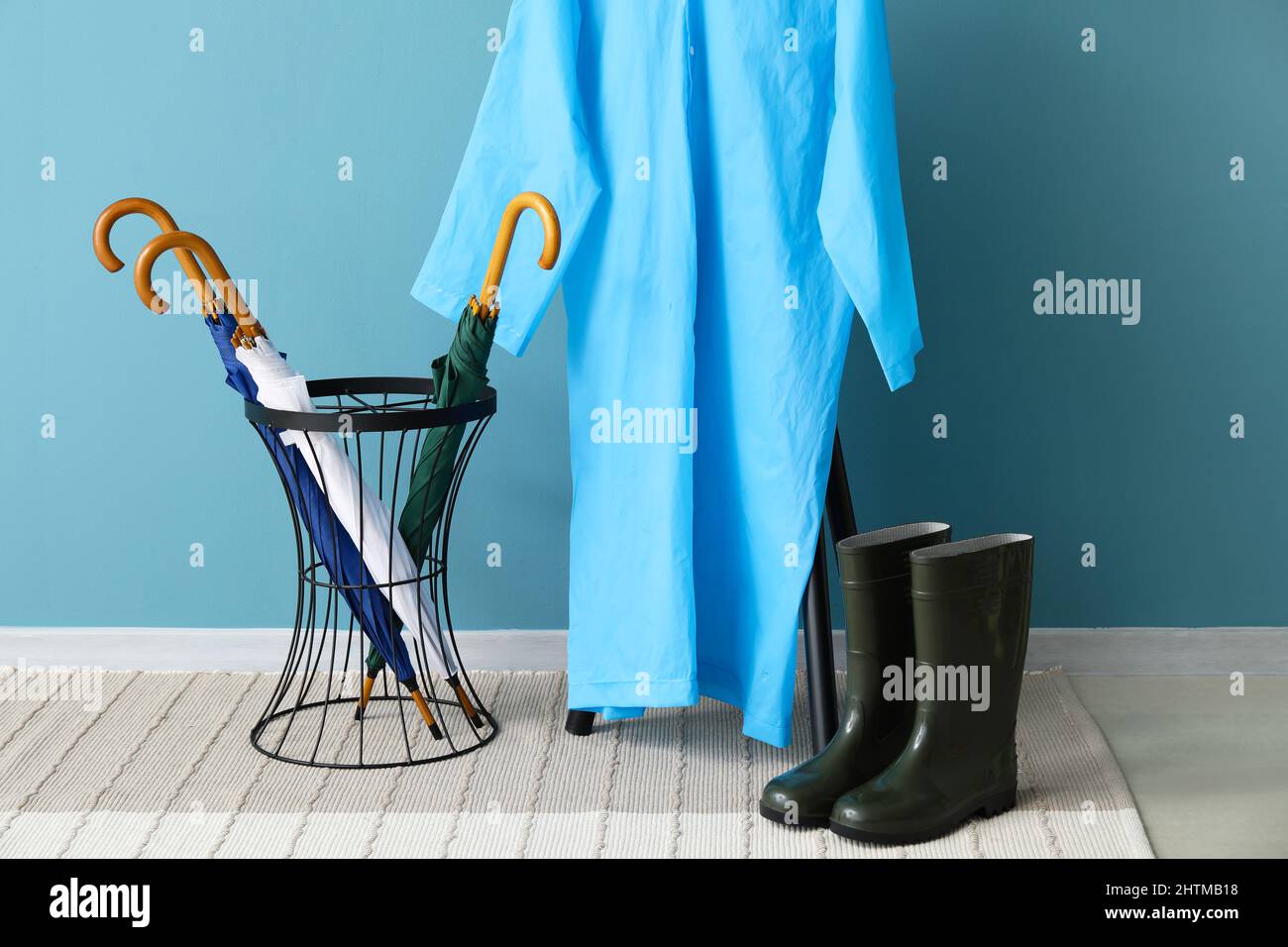Raincoat, gumboots and umbrellas in hallway Stock Photo Alamy