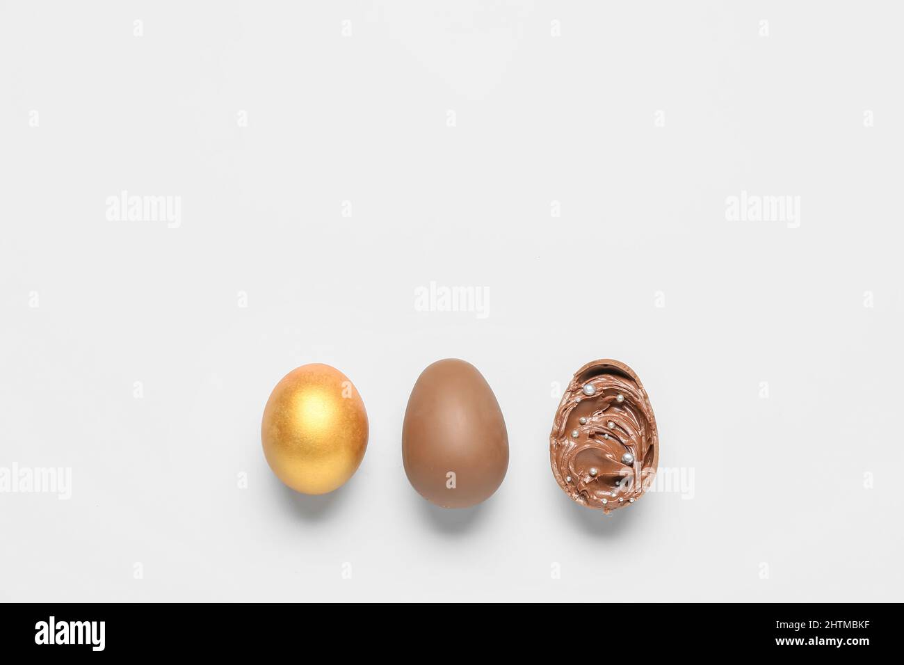 Delicious chocolate eggs with paste filling on light background Stock Photo