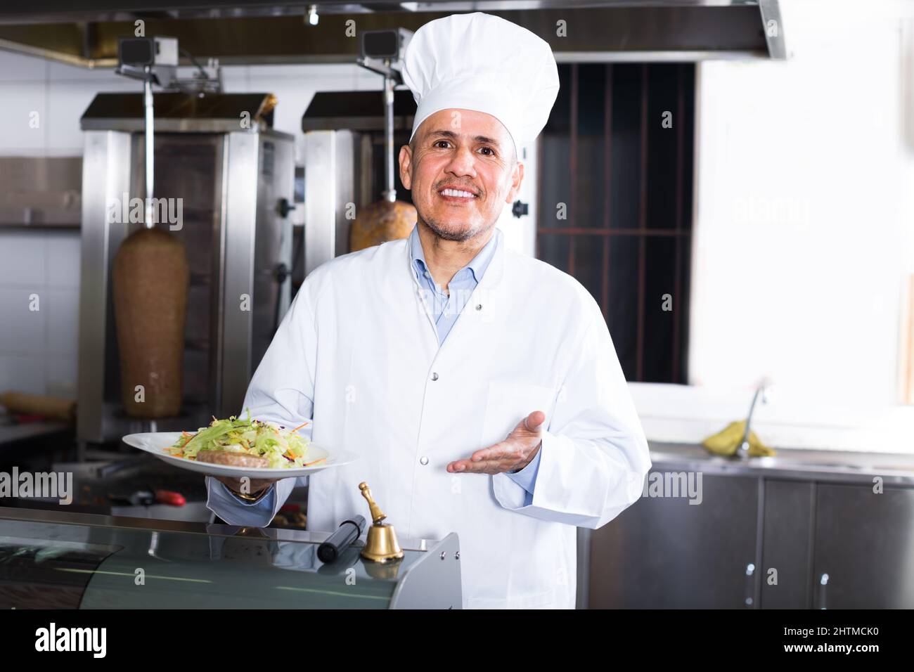 mature chef in fast food restaurant. Stock Photo