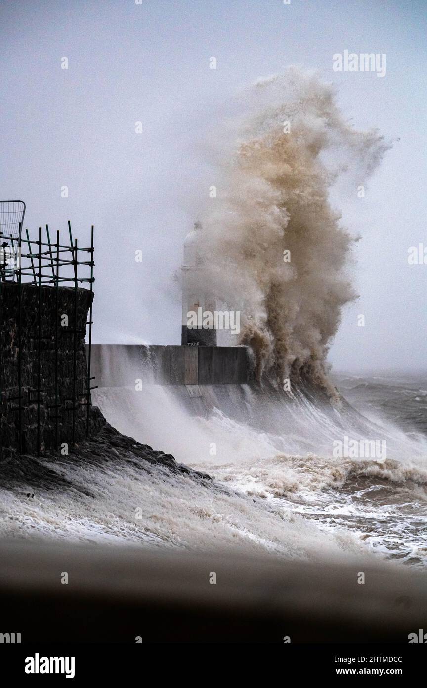 Huge ocean waves crashing into a sea wall and lighthouse Porthcawl ...