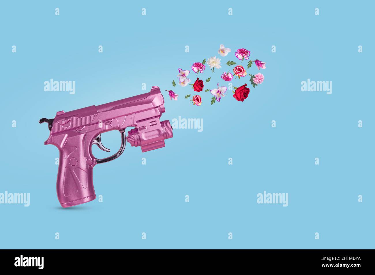 Pink Gun shooting beautiful flowers.  Minimal peace concept. Stop war. Stock Photo