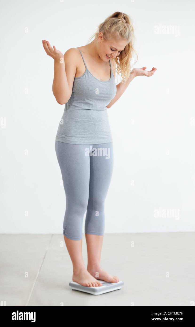 This is better than I expected - Weightloss. Curvaceous young woman standing on her scale. Stock Photo