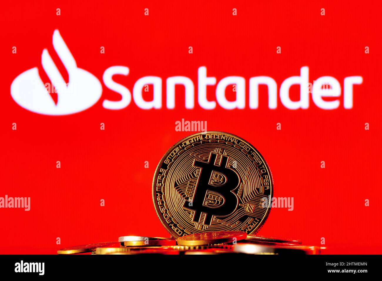 Golden bitcoin in pile of coins on background of Credit Suisse bank logo Stock Photo